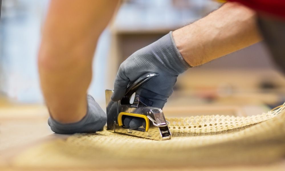 A stapler, staples, and a document with a paper clip with a yellow background.